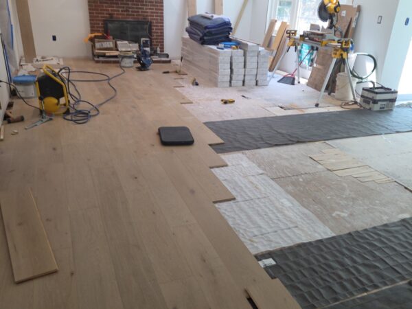 Wide-plank hardwood flooring being installed in the Westford, MA home Wide-plank hardwood flooring being installed in the Westford, MA home